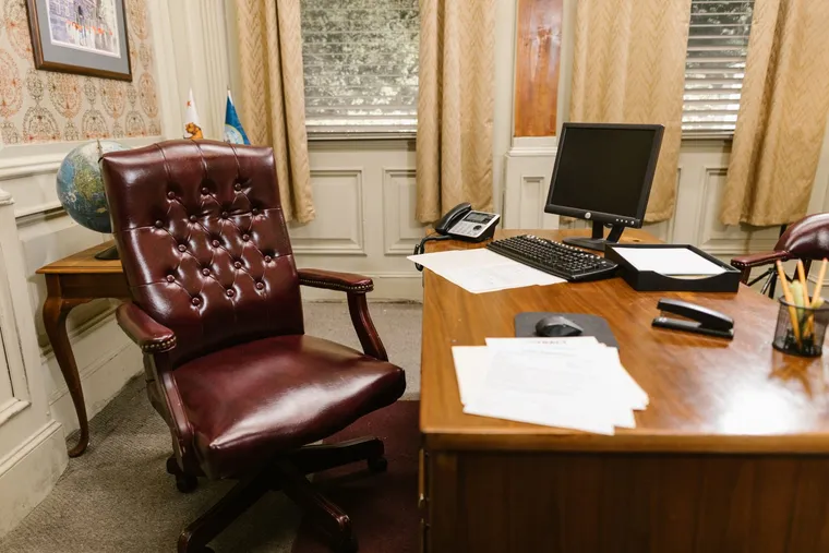 A traditional executive office with a leather chair and antique wooden desk