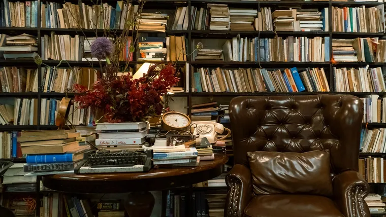 A cozy vintage study with a leather armchair and bookshelves